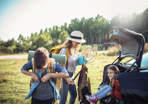 Happy family enjoying picnic and camping holiday in countryside